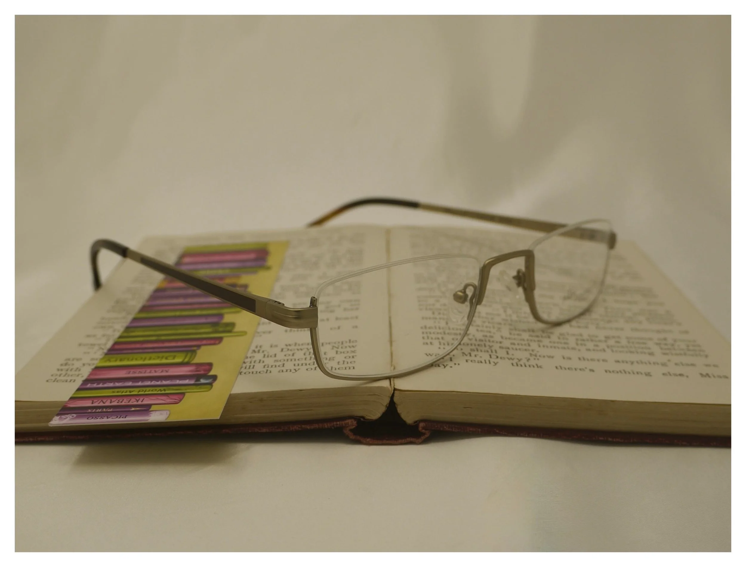 Julian Beaumont 3659 gold titanium reading glasses shown on an open book to demonstrate look-over capability