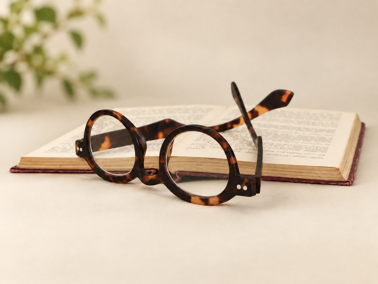 Doctor Shell tortoiseshell reading glasses displayed open in front of a vintage book