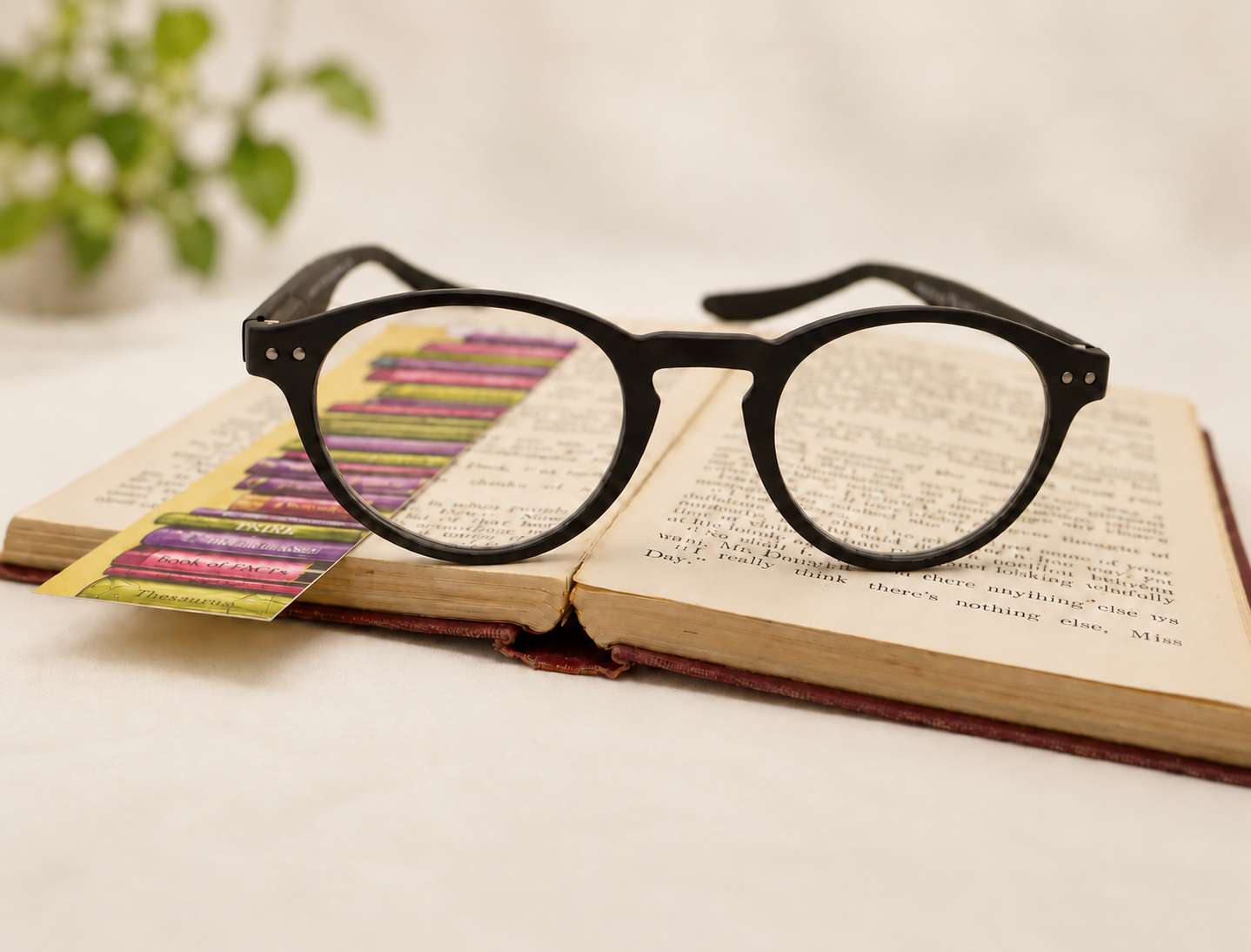 Black Hangover Panto long-arm reading glasses resting on an open book