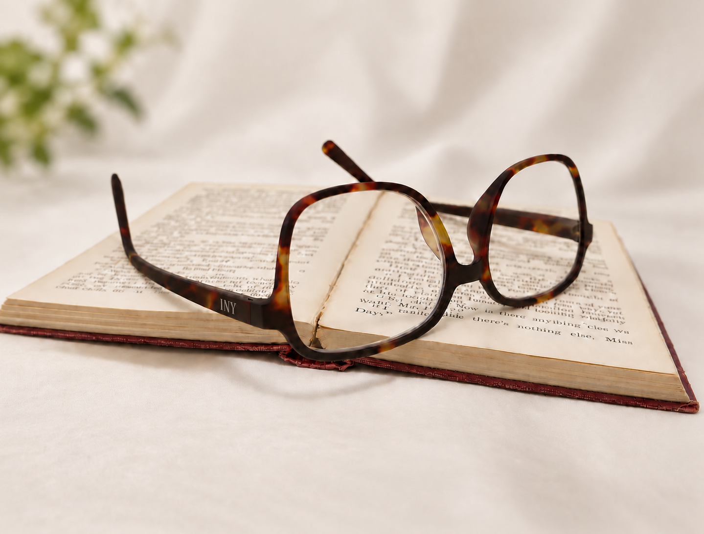 Greta Havana reading glasses resting open on the pages of a book