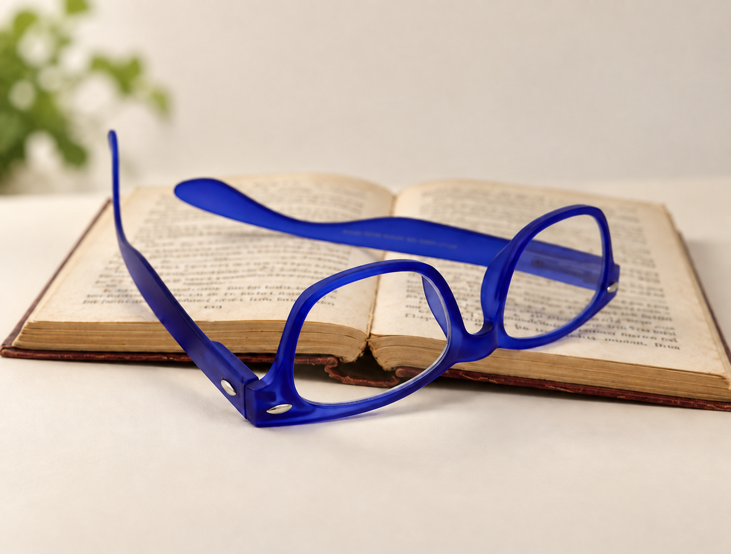 Woody bright blue reading glasses resting across an open book