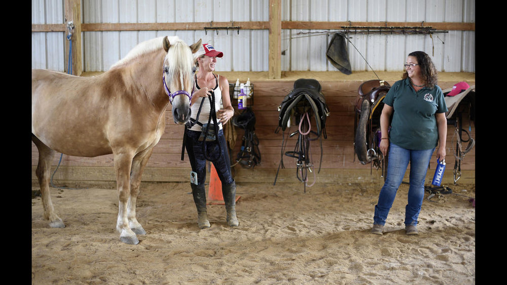 Executive Director Christine Hajek, right, talks with Lauren Bognovitz, left, working with Pandora, a female Haflinger, during a training session at Gentle Giants Draft Horse Rescue in Mount Airy Friday, July 13, 2018. 