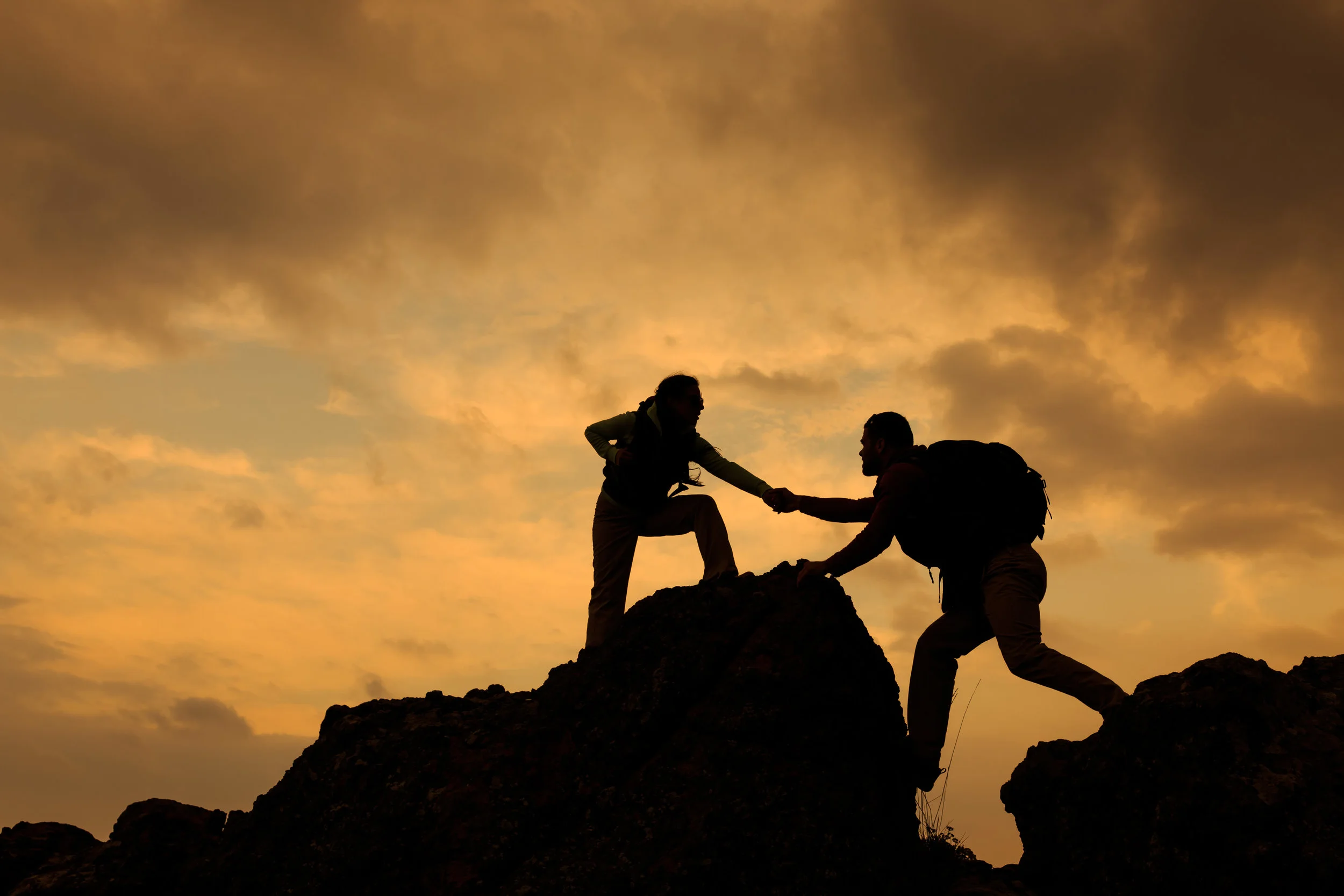 Man-and-woman-help-silhouette-in-mountains-489516138_5612x3741 (1).jpeg