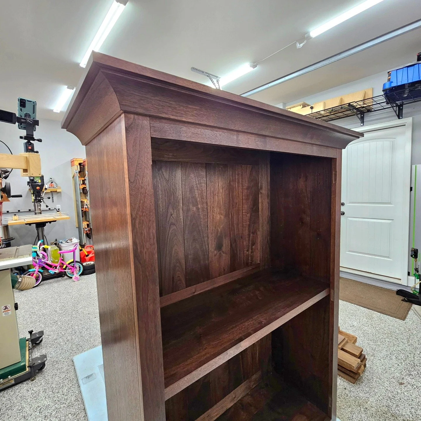 "How did you attach the molding to allow for wood movement?" Great question!

"You can fix the back end of the molding with a screw driven from inside the case. The screw passes through a slotted pilot in the case side, so the side can