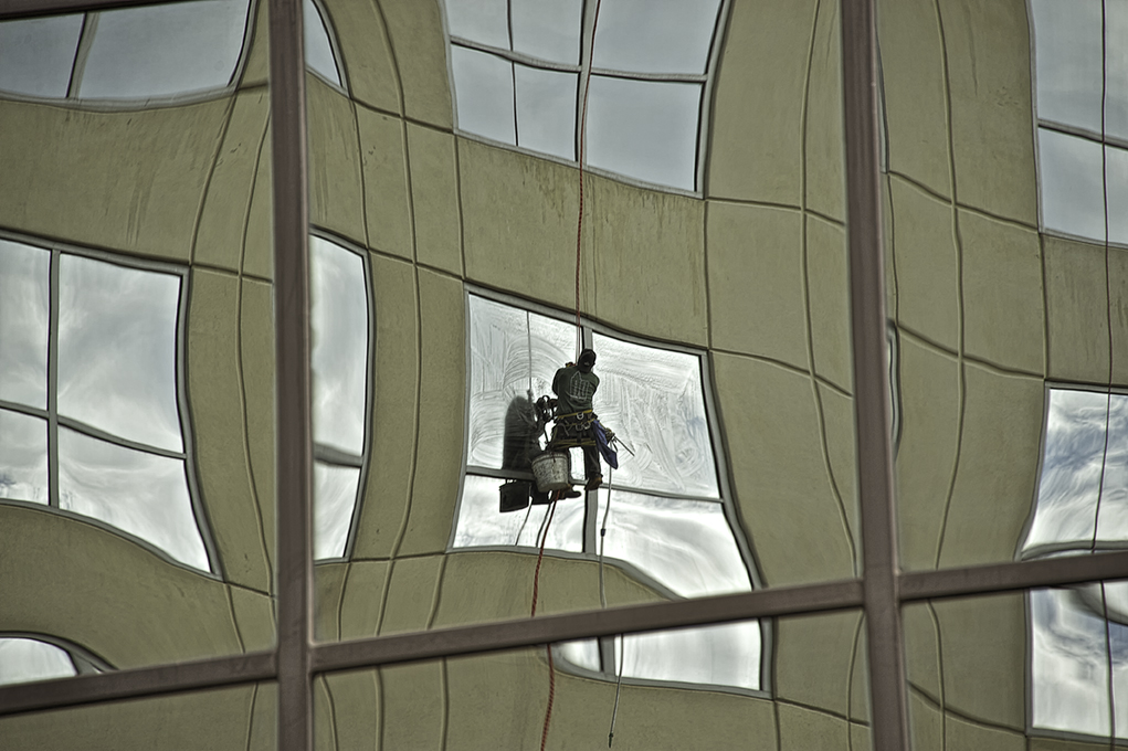 Reflection of the window cleaner across the road