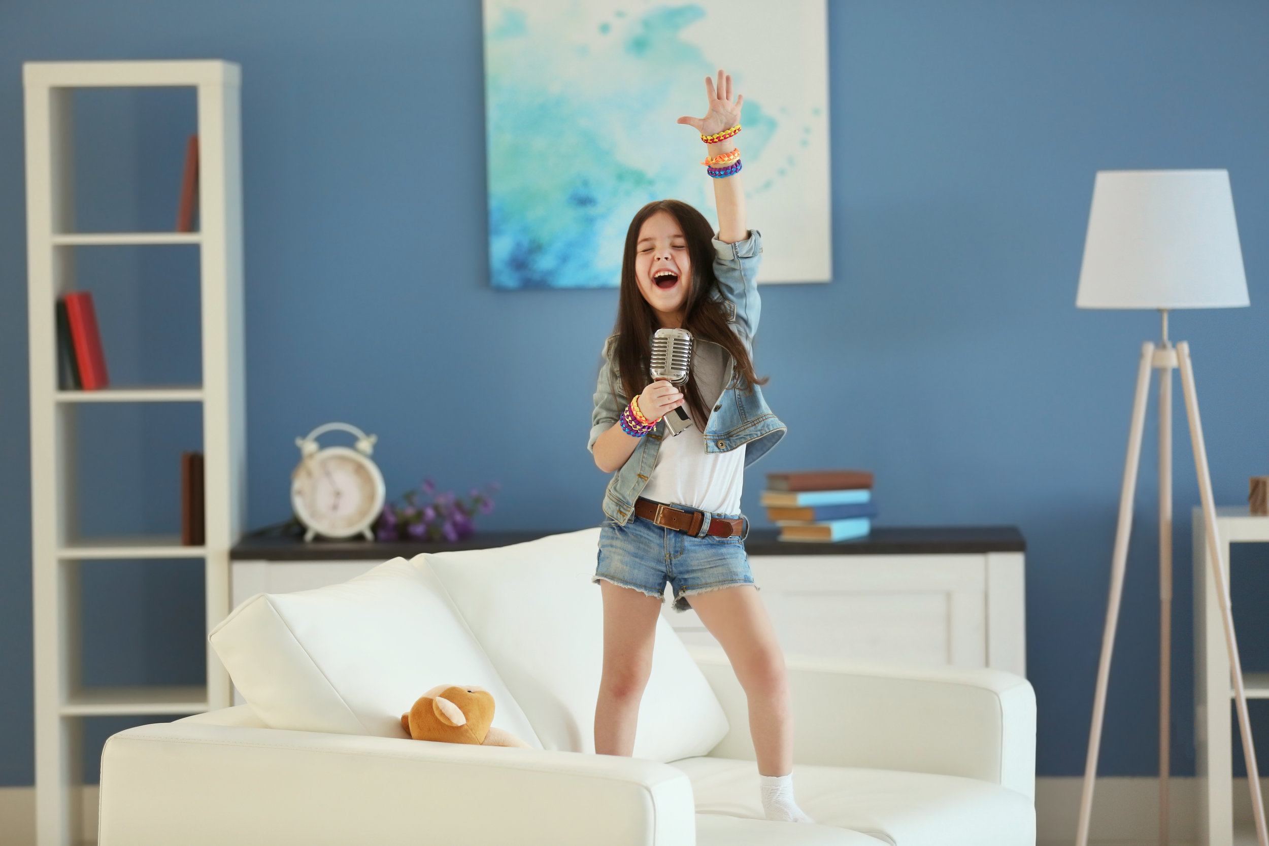 Artistic little girl singing in the room