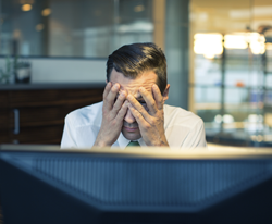 Man with face in hands@computer.png