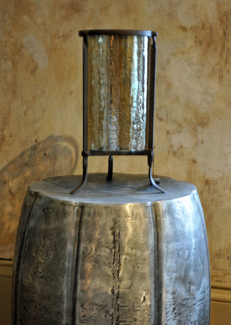   Estoria Hurricane  $110 Hand Forged Iron Base with Ripple Glass Vase   Jada Side Table  $385 Embossed Aluninum 