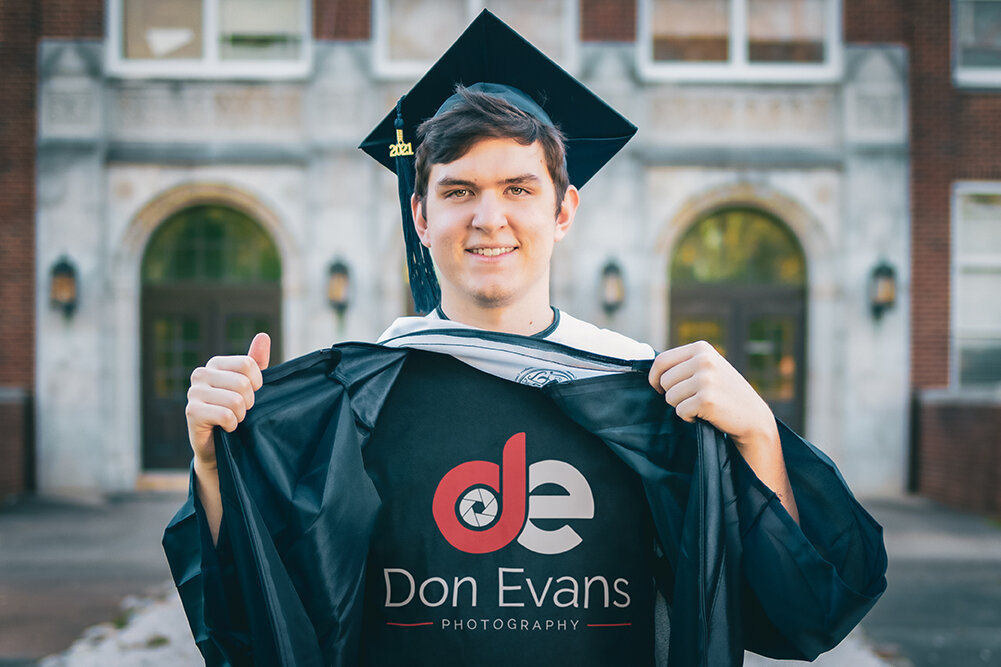 High School Senior opens his robe to reveal his photographer Don Evans Photography logo during his Senior Pictures photo session in Greensboro NC.jpg