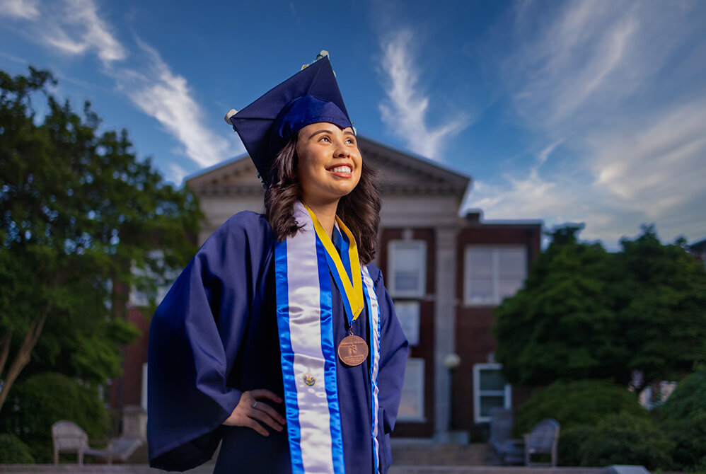 college senior graduate stands in front of the building that she spent the last four years studying in - taken by Don Evans Photography in Greensboro NC.jpg