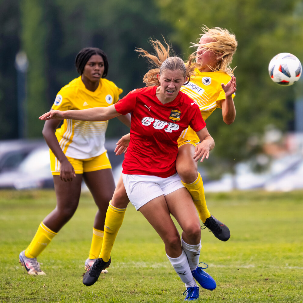  two girls academy league soccer players collide during their national tournament in Bryan Park Soccer Complex taken by Don Evans Photography in Greensboro NC 