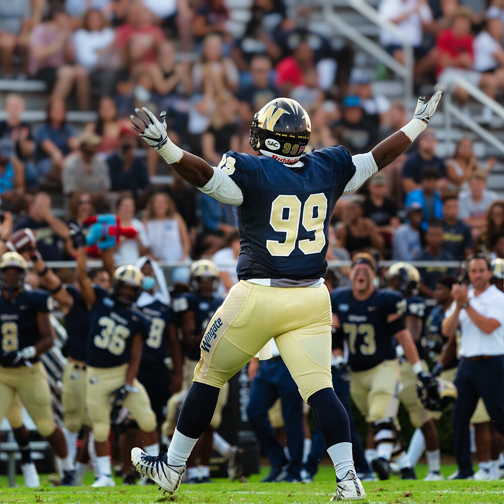 college football defensive tackle celebrates after sacking the quarterback and causing a fumble at wingate university by Don Evans Photography in Greensboro NC.jpg