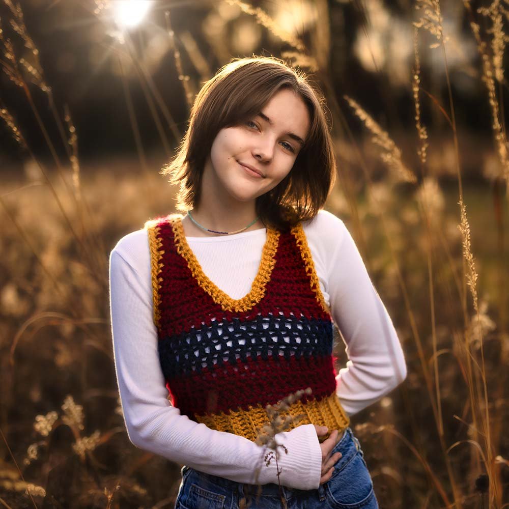 Don Evans Photography in Greensboro high school senior stands in a field of tall grass with the sun setting behind her during her senior picture photo session.jpg