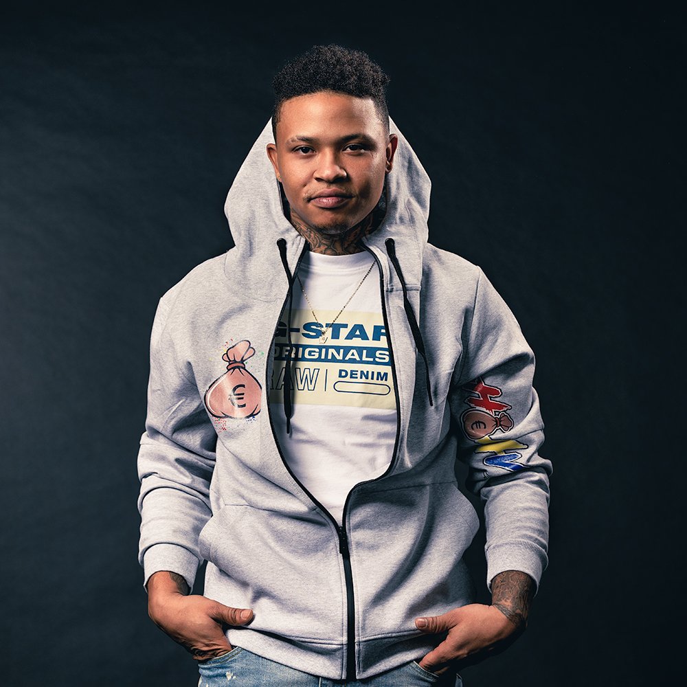 Don Evans Photography in Greensboro man wearing jeans and a hoodie stands with hands in his pockets during his in studio portrait photo session.jpg