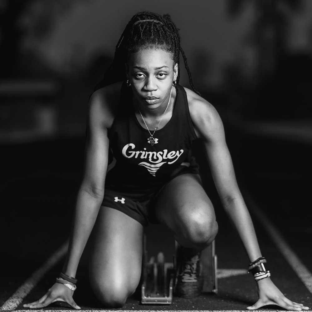 Don Evans Sports Photography in Greensboro NC high school senior track athlete lines up on the starting blocks during her senior picture photo session