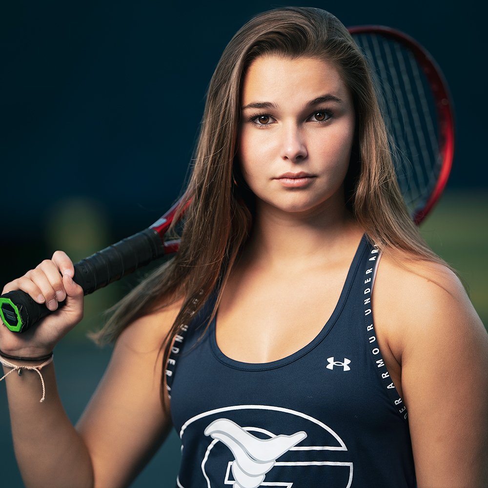 Don Evans Photography in Greensboro picture of a womens tennis player holding her racket and looking at the camera during a senior portrait photo session