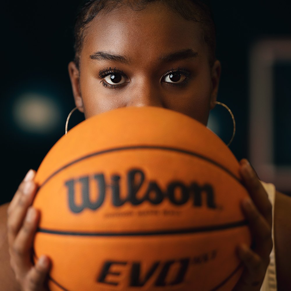 Don Evans Sports Photography in Greensboro NC high school basketball player stares over top of a basketball during her school sports photo session.jpg