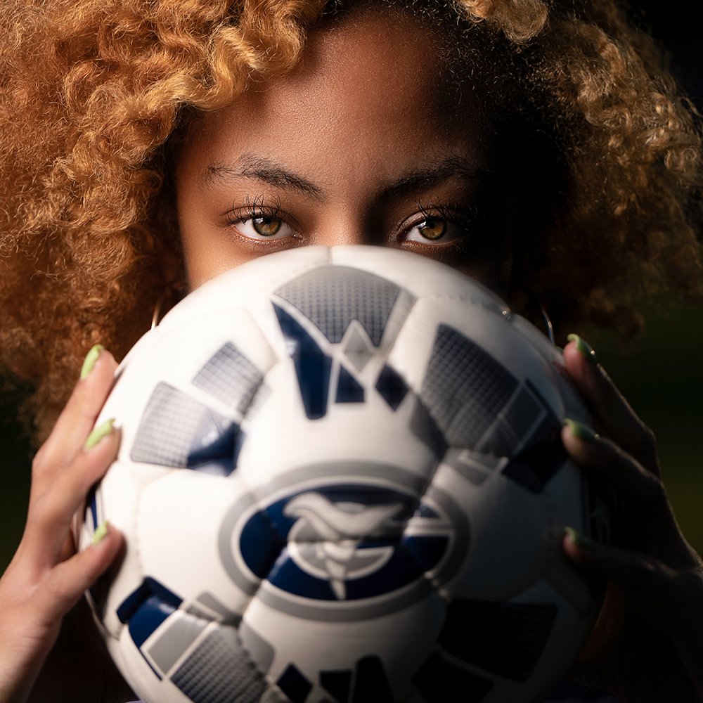 Don Evans Sports Photography in Greensboro NC high school senior soccer player over top of a ball during her senior sports portrait and banner photo session.jpg