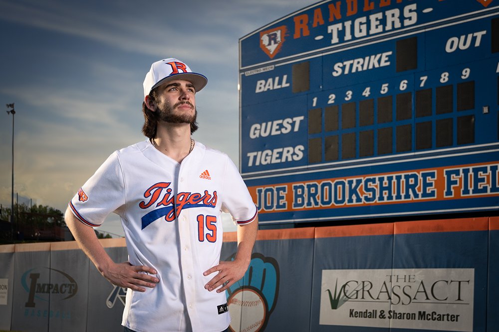 Don Evans Photography in Greensboro picture of a senior baseball player standing in the outfield during his senior pictures photo session