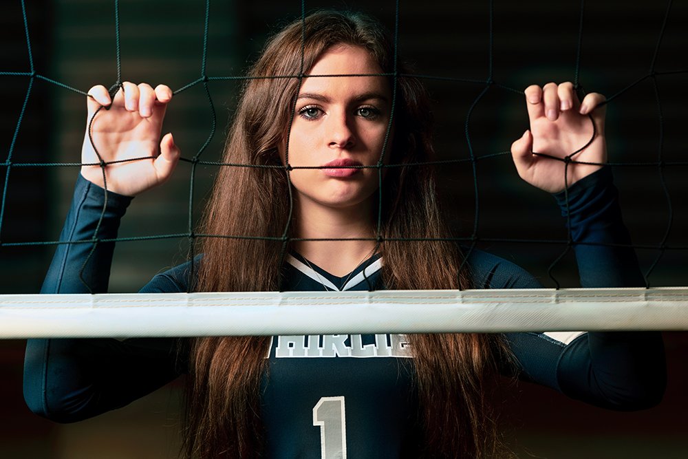Don Evans Photography in Greensboro NC image of a volleyball player grabing the net during her senior sports portrait