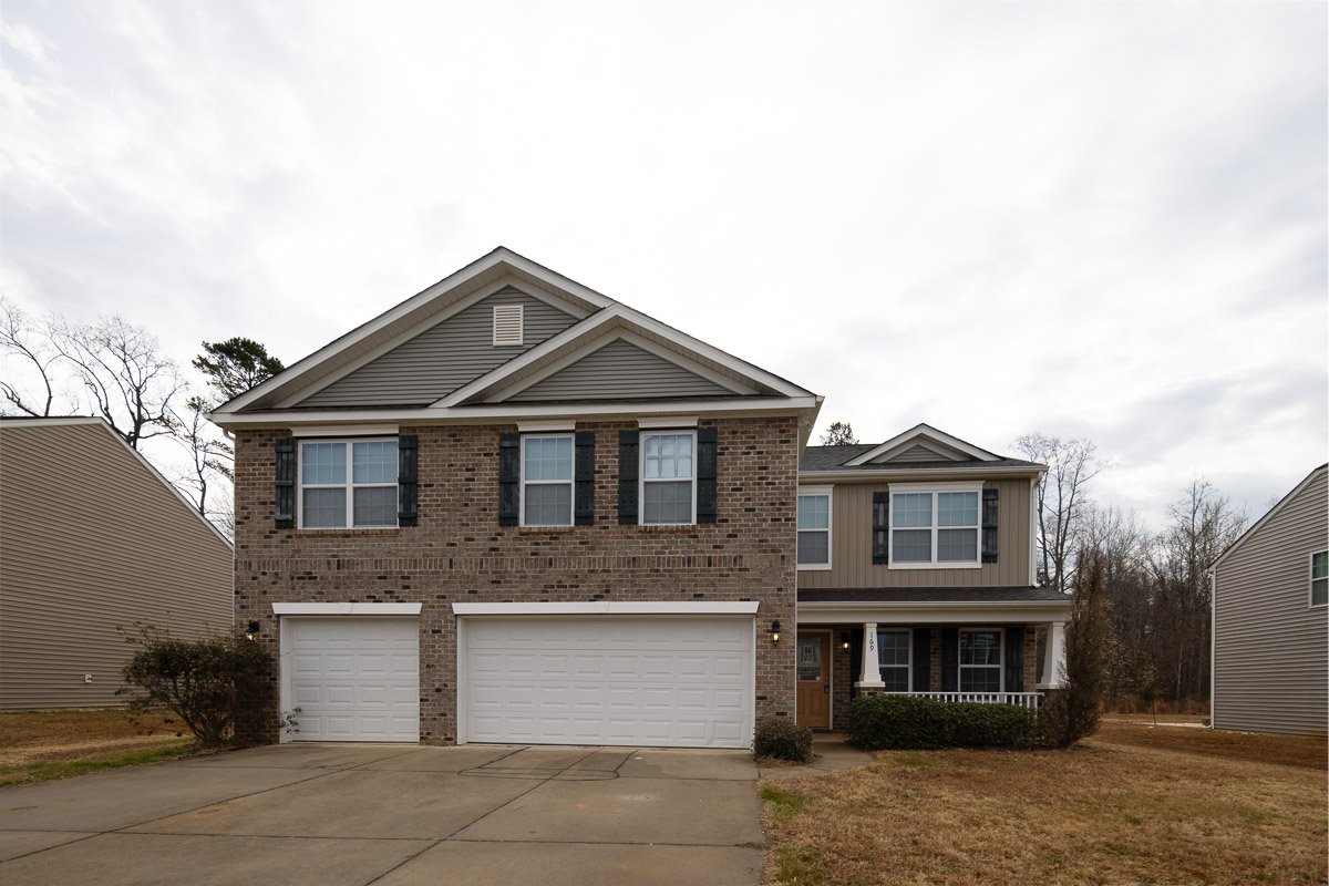 Original real estate exterior with overcast sky before signature editing