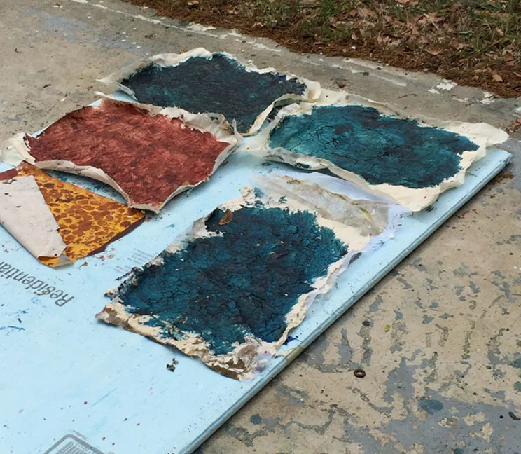 Fabric pieces with wheat paste plus paint, out in the sun to dry.