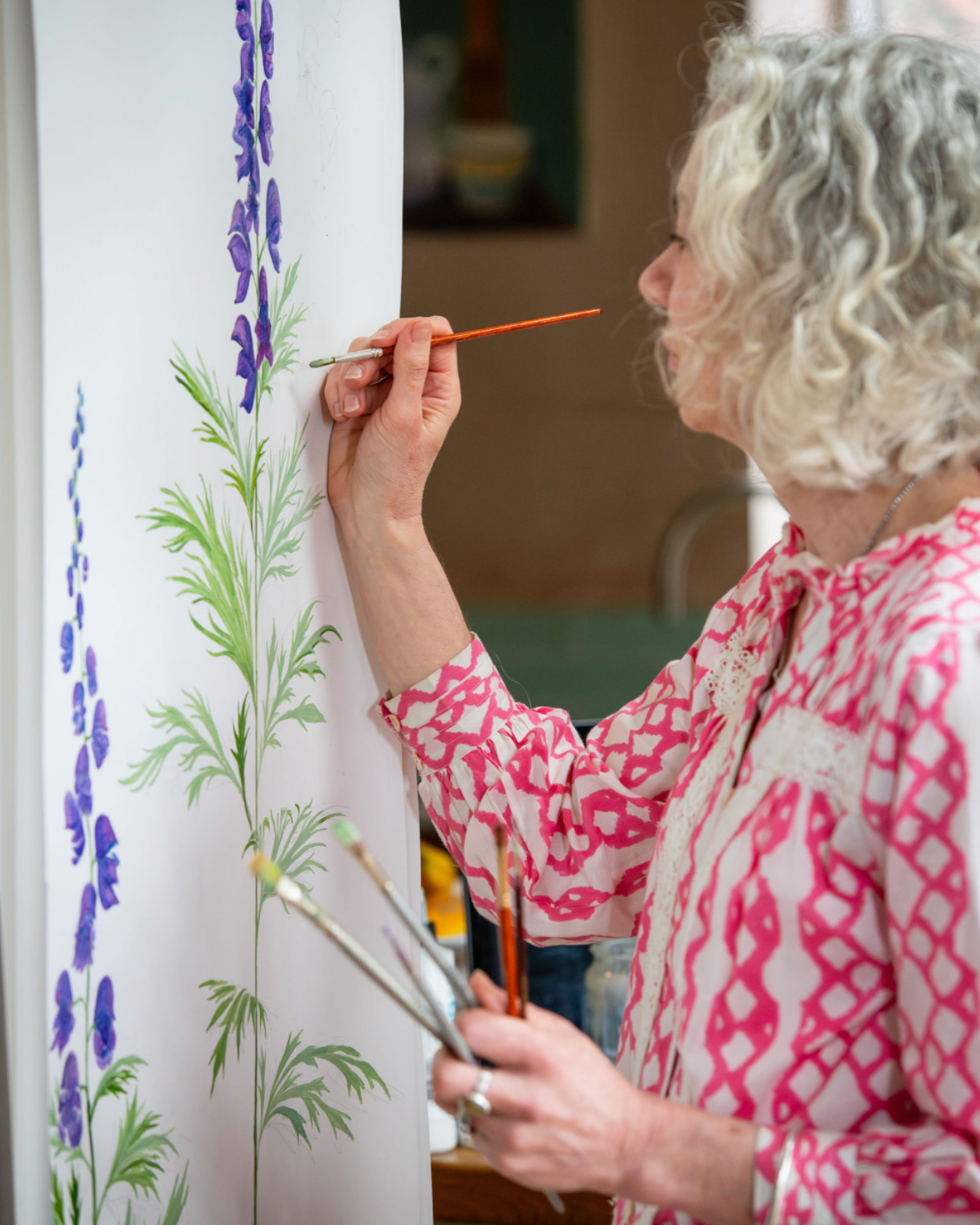 Artist painting Monkshood flowers mural