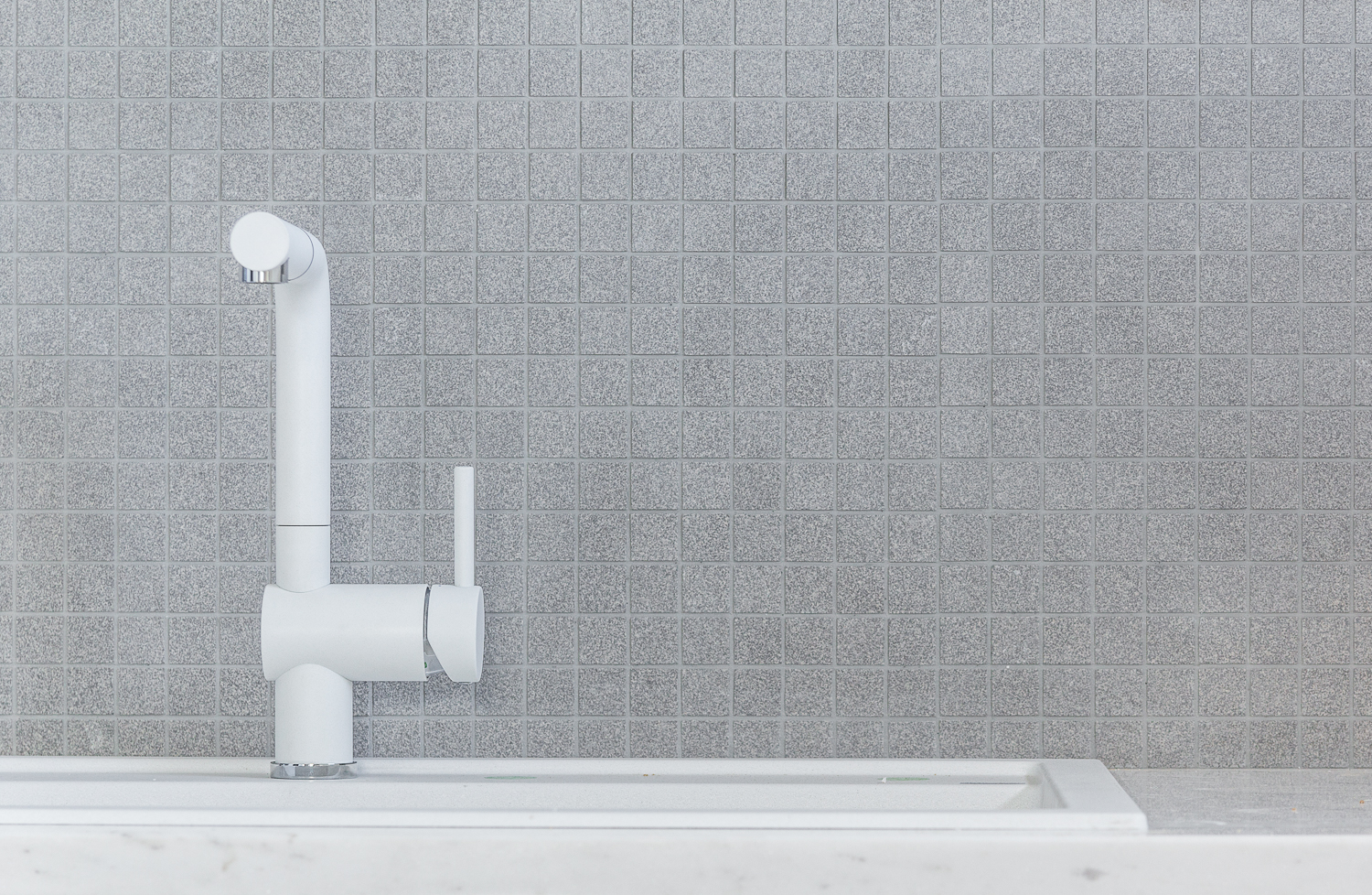 Close up of the kitchen tap and tiles.