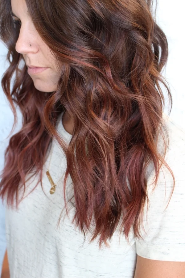 Brunette balayage with warm red tones created at a private hair studio in Carmel, Indiana.