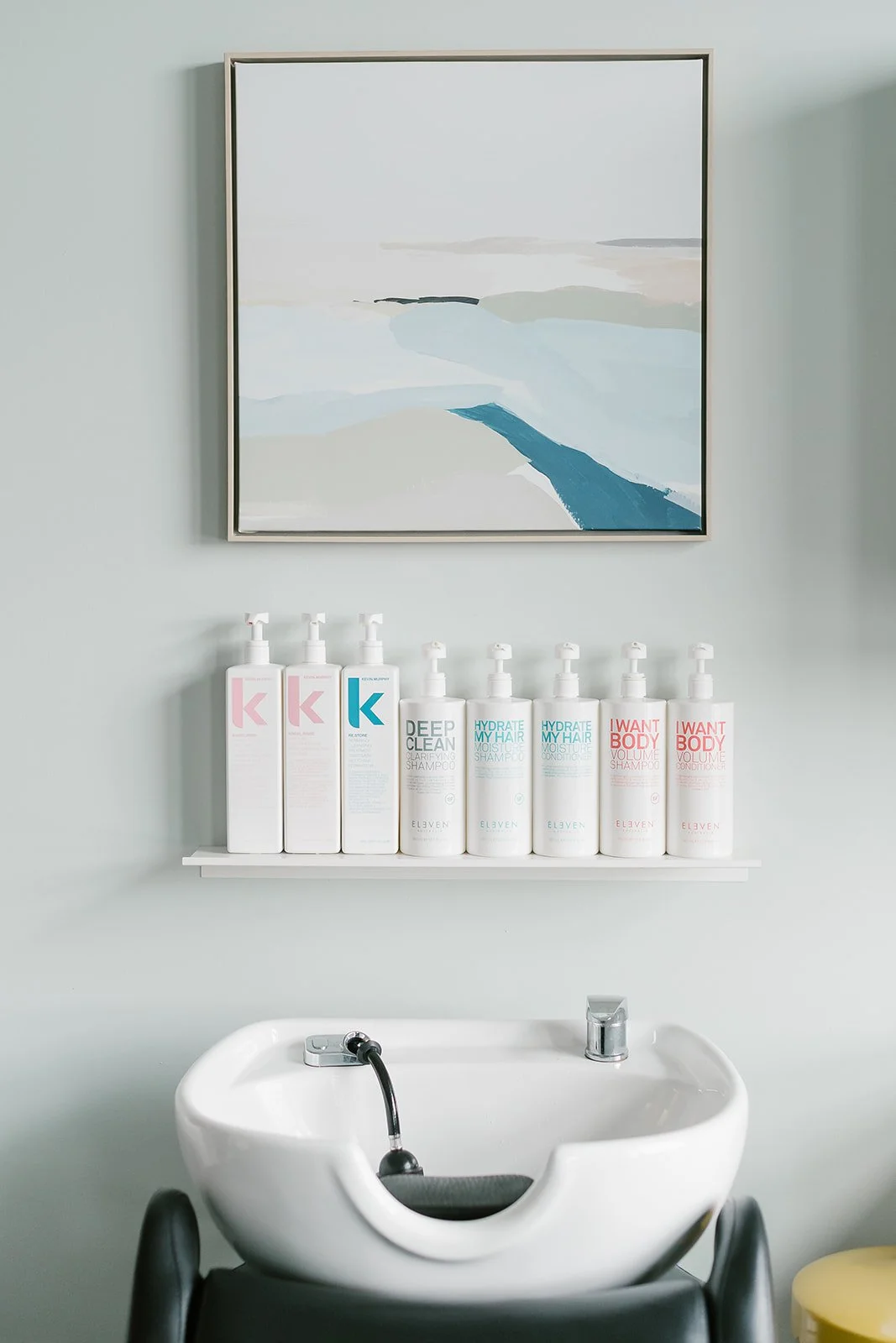 Close-up of a shampoo bowl and backbar in a modern hair studio in Carmel, Indiana.