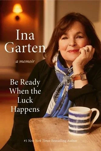 Cover of the memoir 'Be Ready When the Luck Happens' by Ina Garten. The cover features a warm-toned photograph of Ina Garten seated at a table with her hand resting on her chin, smiling gently.