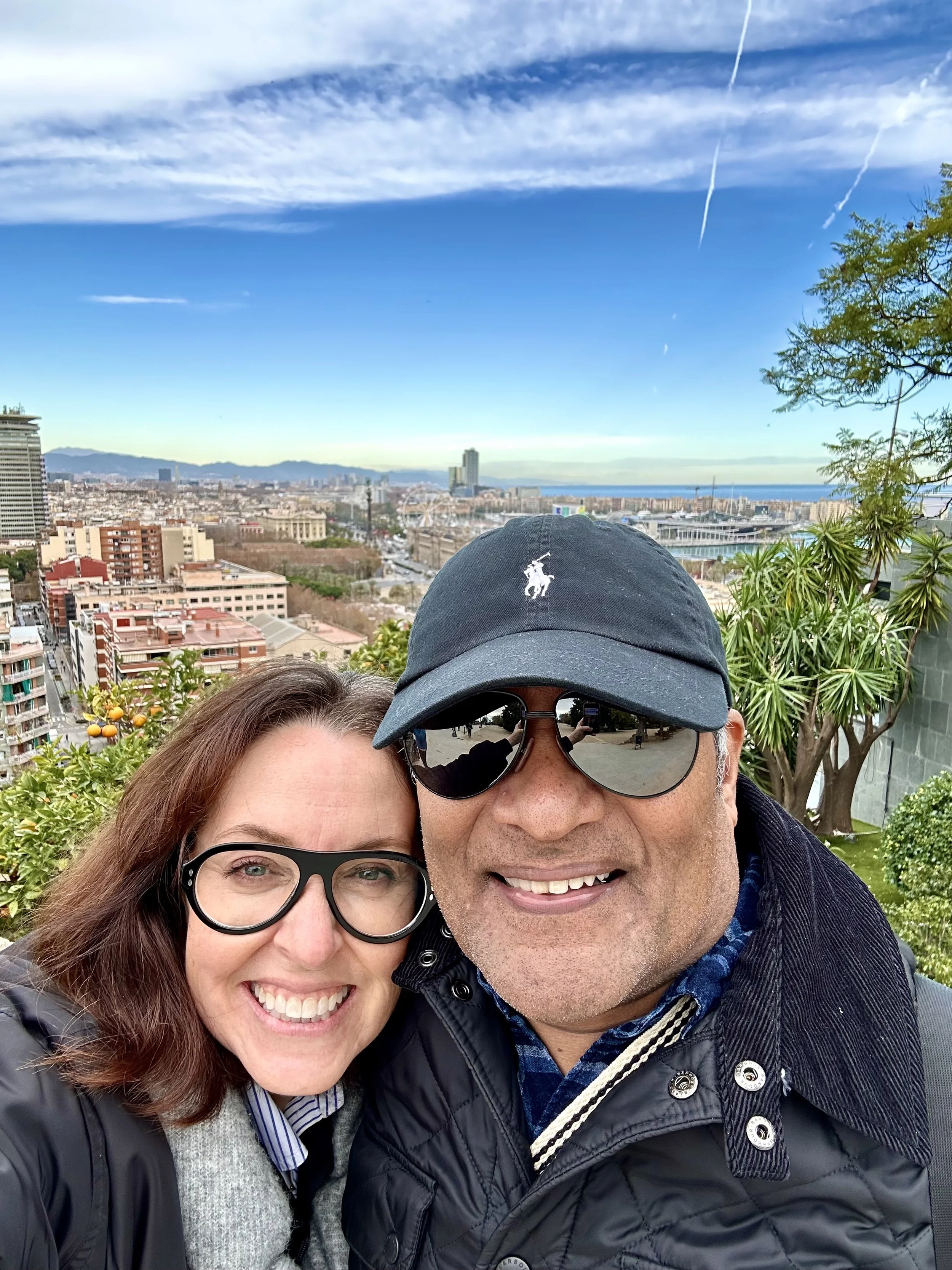 A couple smiling with panoramic view of Barcelona from MontJüic