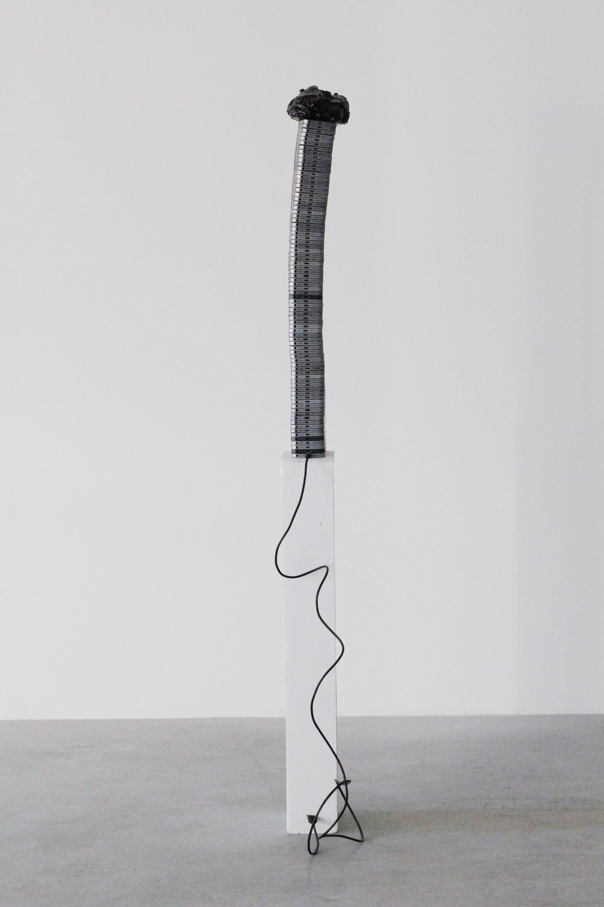 Untitled (Too Thick), 2018 Aluminum phone casings, silicone, polyurethane, asphalt, wood, Lightning to USB cord (photo courtesy HOUSING, Brooklyn, NY)