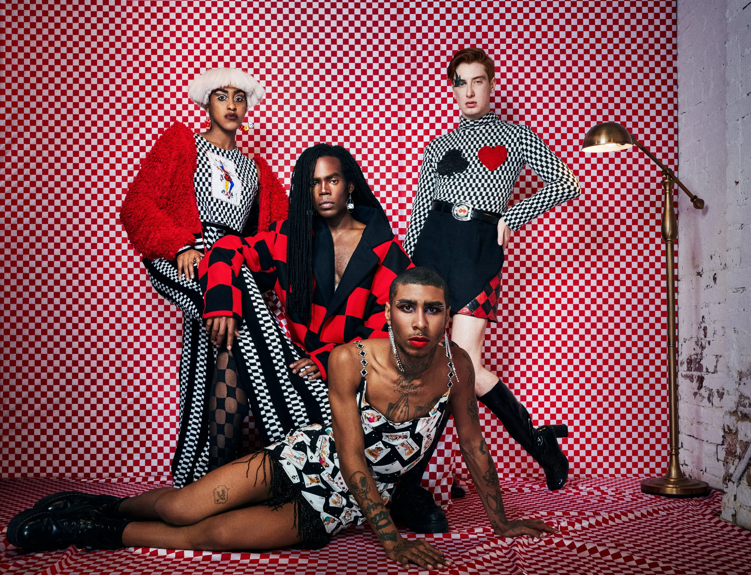 Eric: Patchwork Checker Wool Coat Dash: Checker knit turtleneck with beaded playing card patches, black wool shorts with checker leather inserts Jewell: Checker and black striped knit pants, joker tank, and red furry bomber Tommy: Vintage pinup p