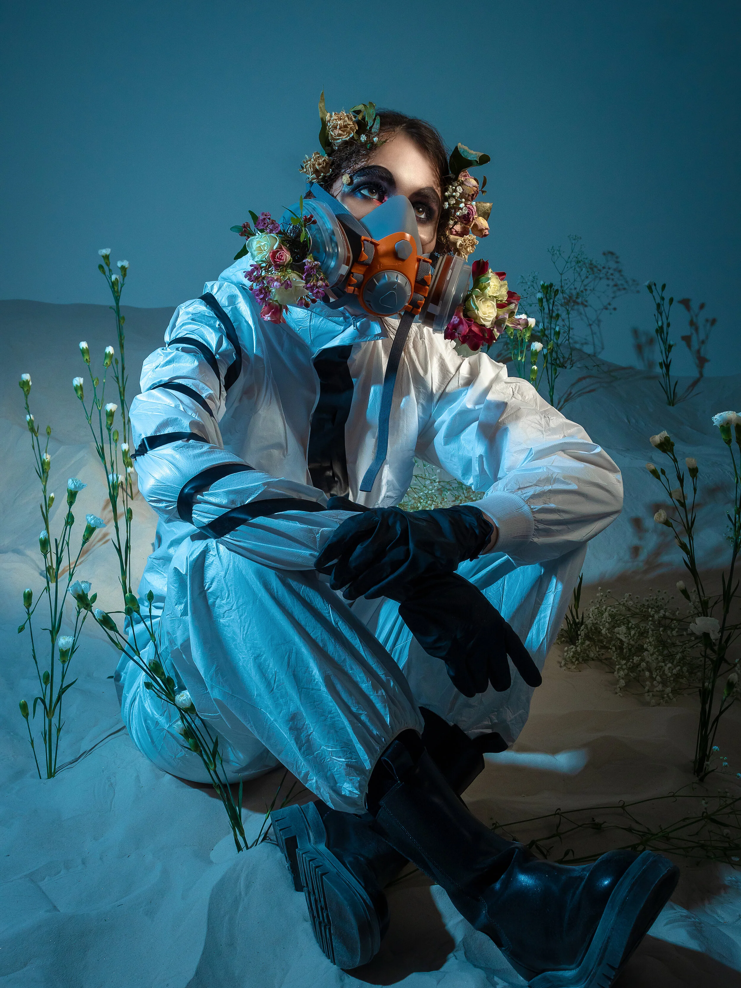 The desert, a man in a protective suit, flowers on a lifeless background as a reminder of the beauty of nature. (Copy)