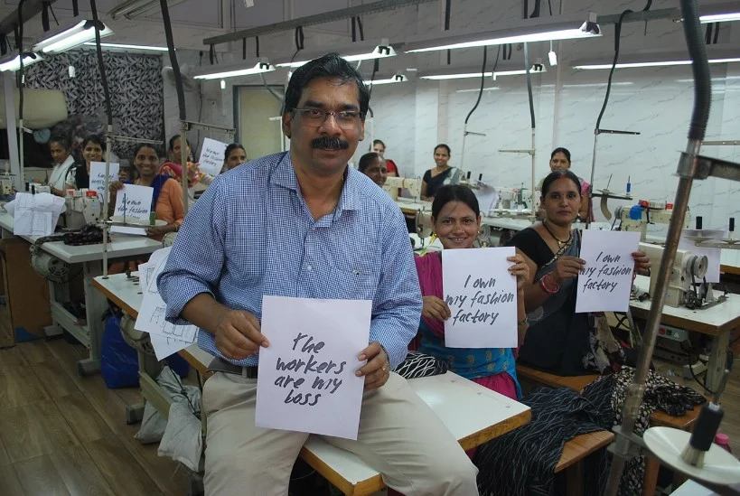 Johny Joseph, Director of Creative Handicrafts, a Fair Trade Enterprise based in Mumbai, India, holds a placard alongside garment workers in his factory. Credit: WFTO