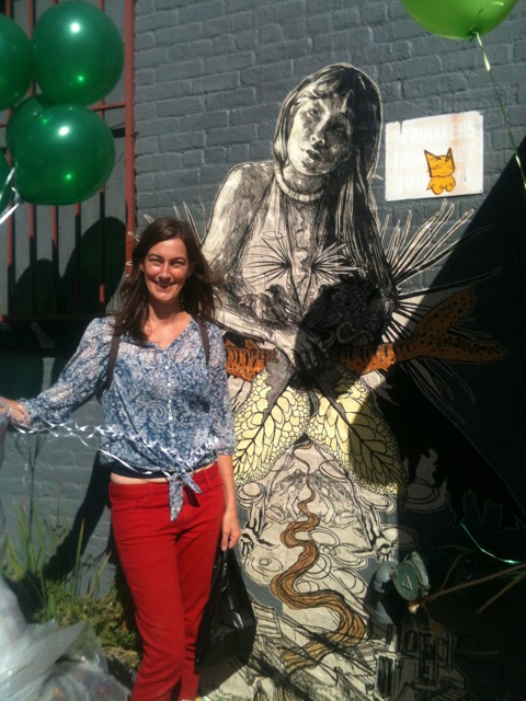 Arts Gowanus Director, Abby Subak, poses in front of the wheatpaste installation by street artist Swoon in honor of Gowanus Open Studios 2013.