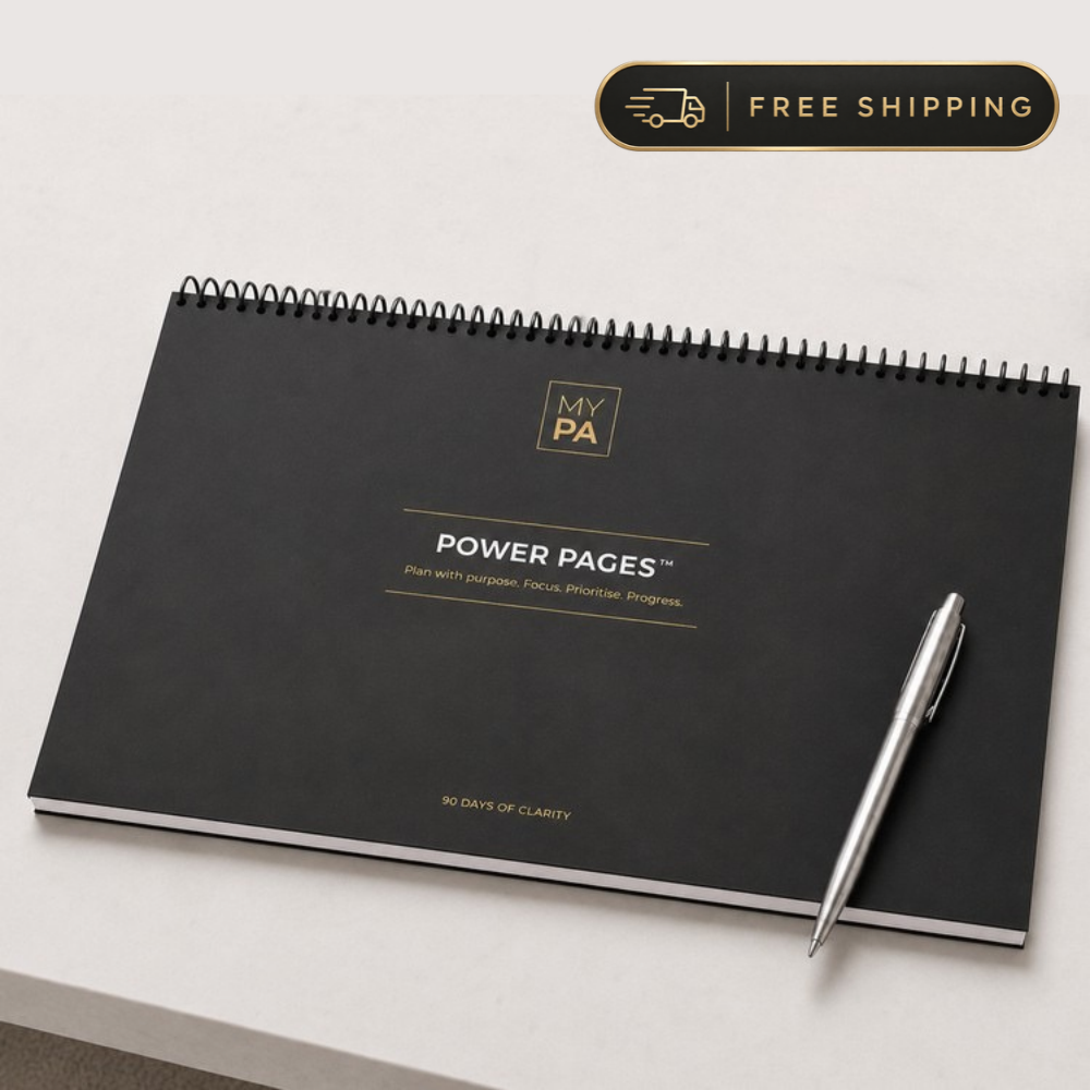 Power Pages Daily planning pad, black and gold cover, on a desk with coffee, watch and glasses
