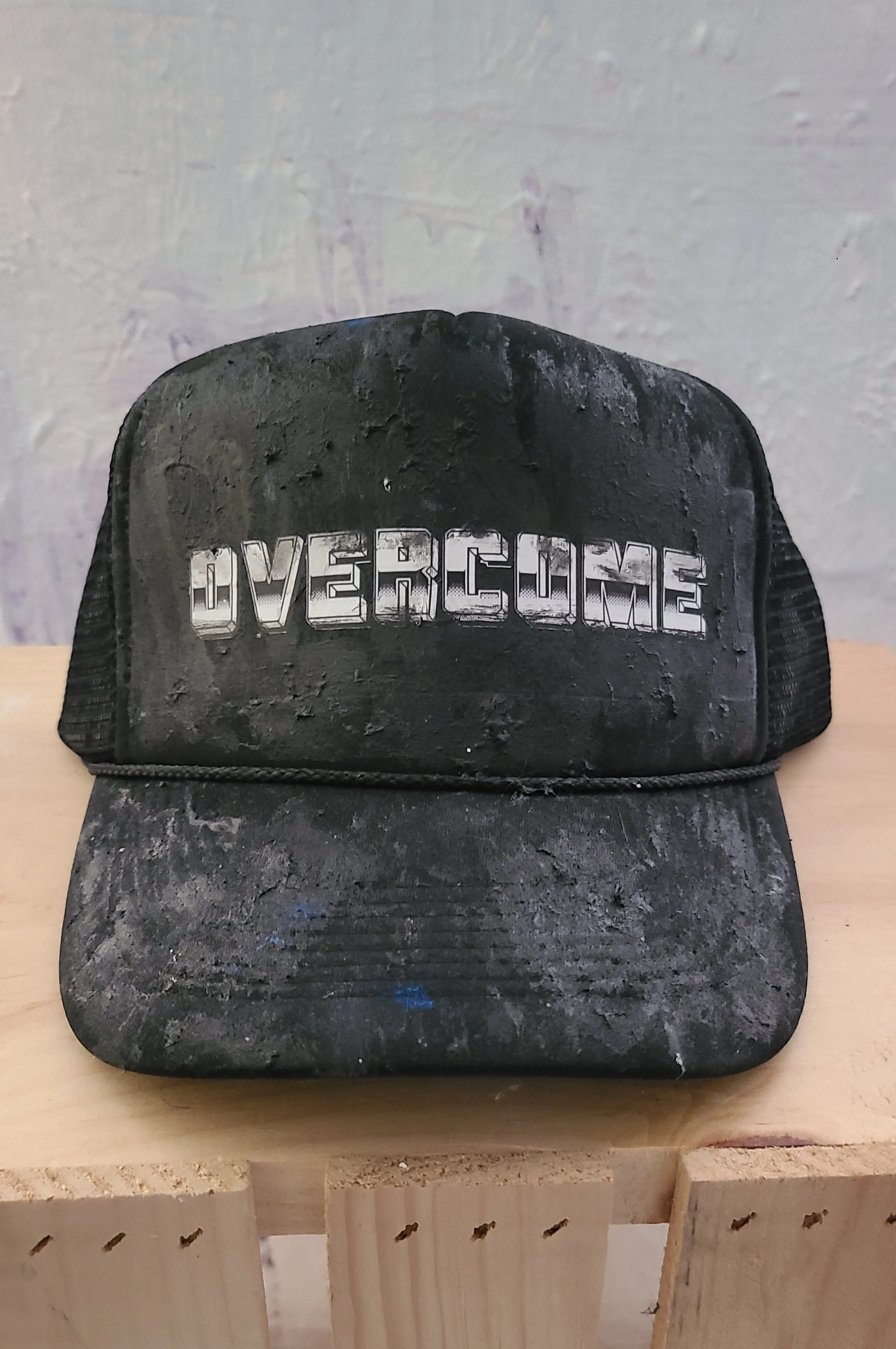 "Overcome" chrome oil leak painted mesh trucker cap.