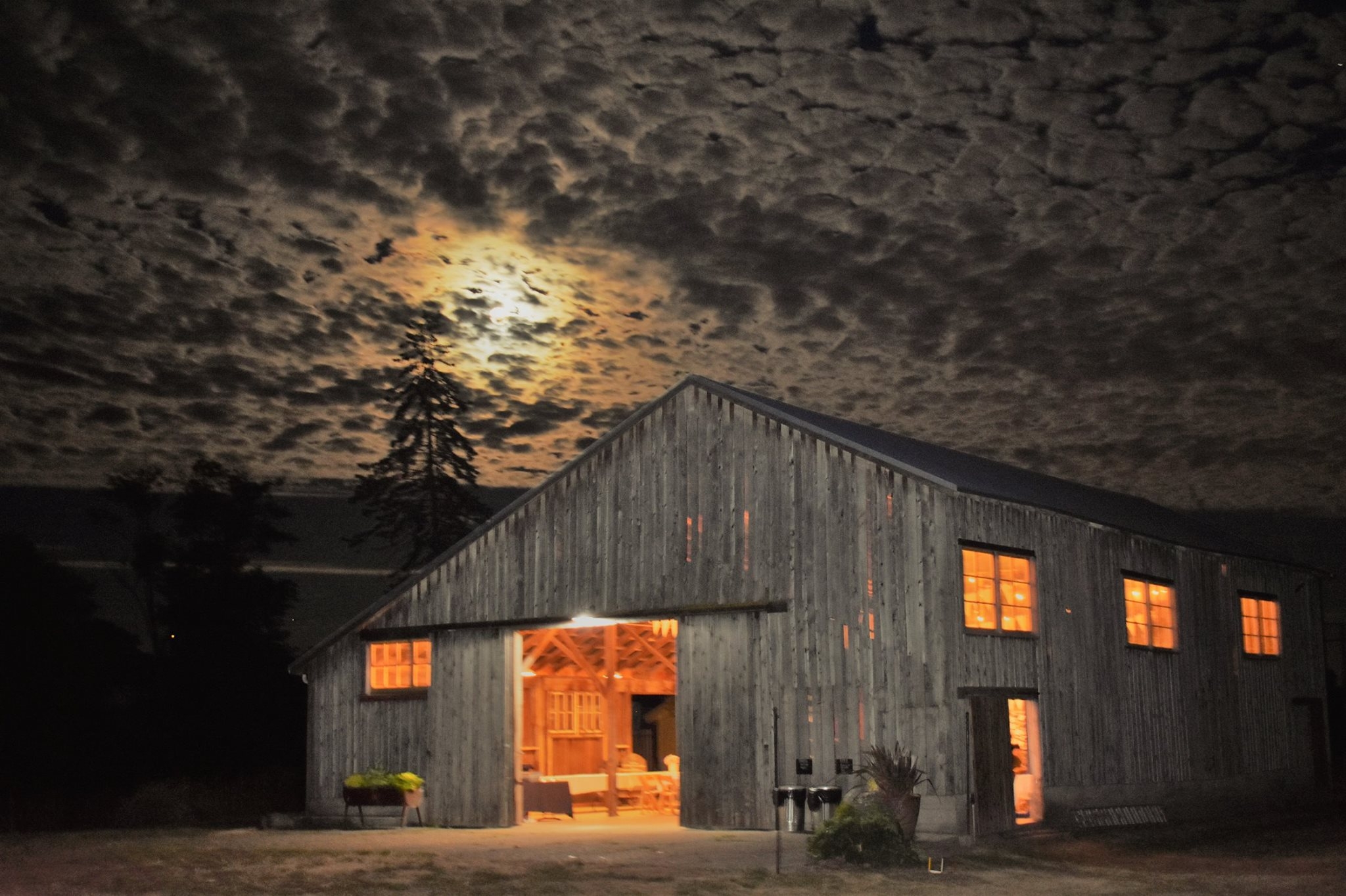 the event barn at night, a full buck moon is seen through a unique cloud covering