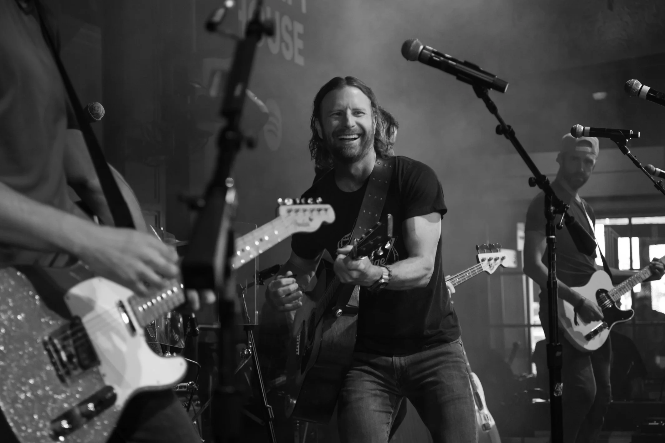 Musician performing live on stage with audience enjoying the show, photographed by Rock and Rae Media.
