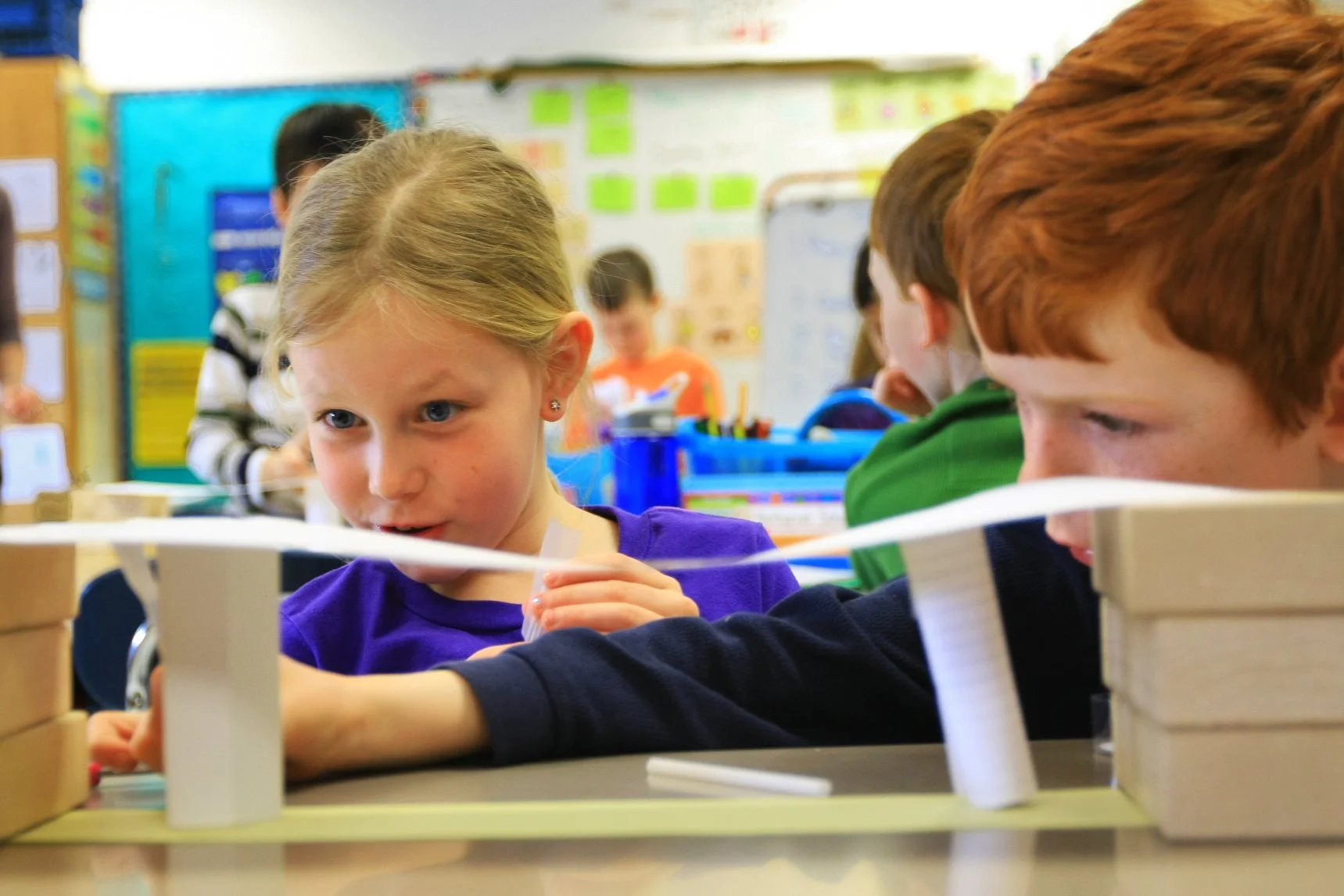 Two kids working together on an engineer challenge