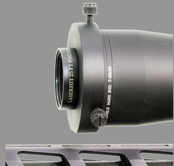 LaserHIT 25-foot Scope Focus Adapter attached to a rifle scope for short-distance indoor focusing.