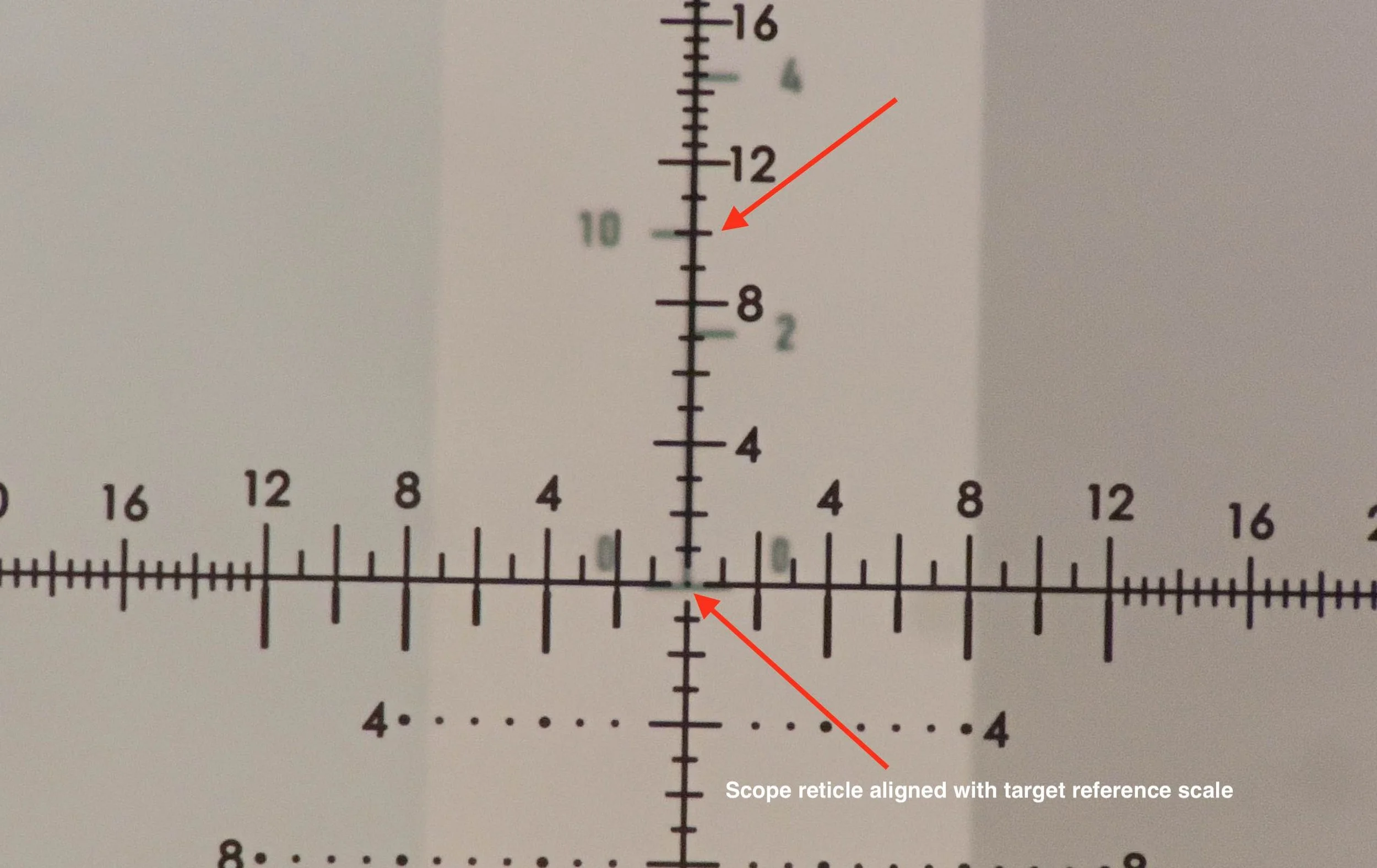 Scope reticle aligned with target reference scale for laser calibration