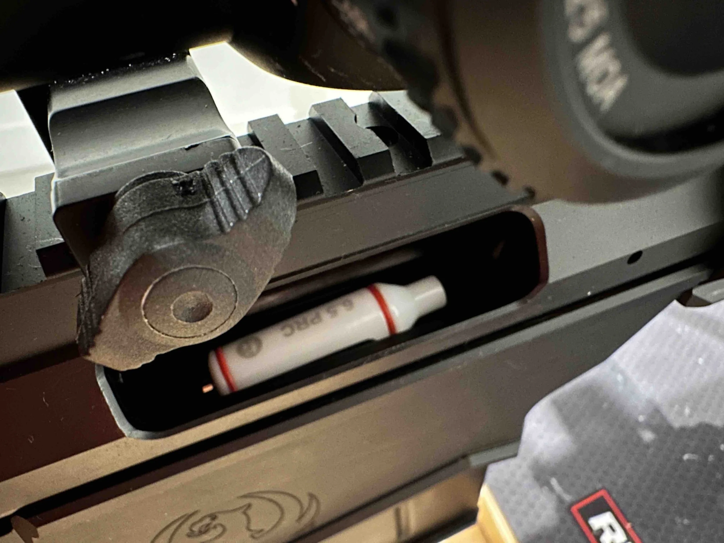 Custom laser cartridge loaded into rifle action, ready for chambering and training setup