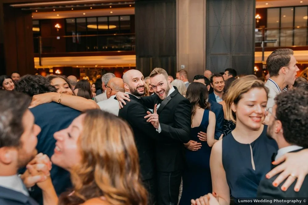 People dancing and celebrating at a wedding reception in the TWA Hotel.