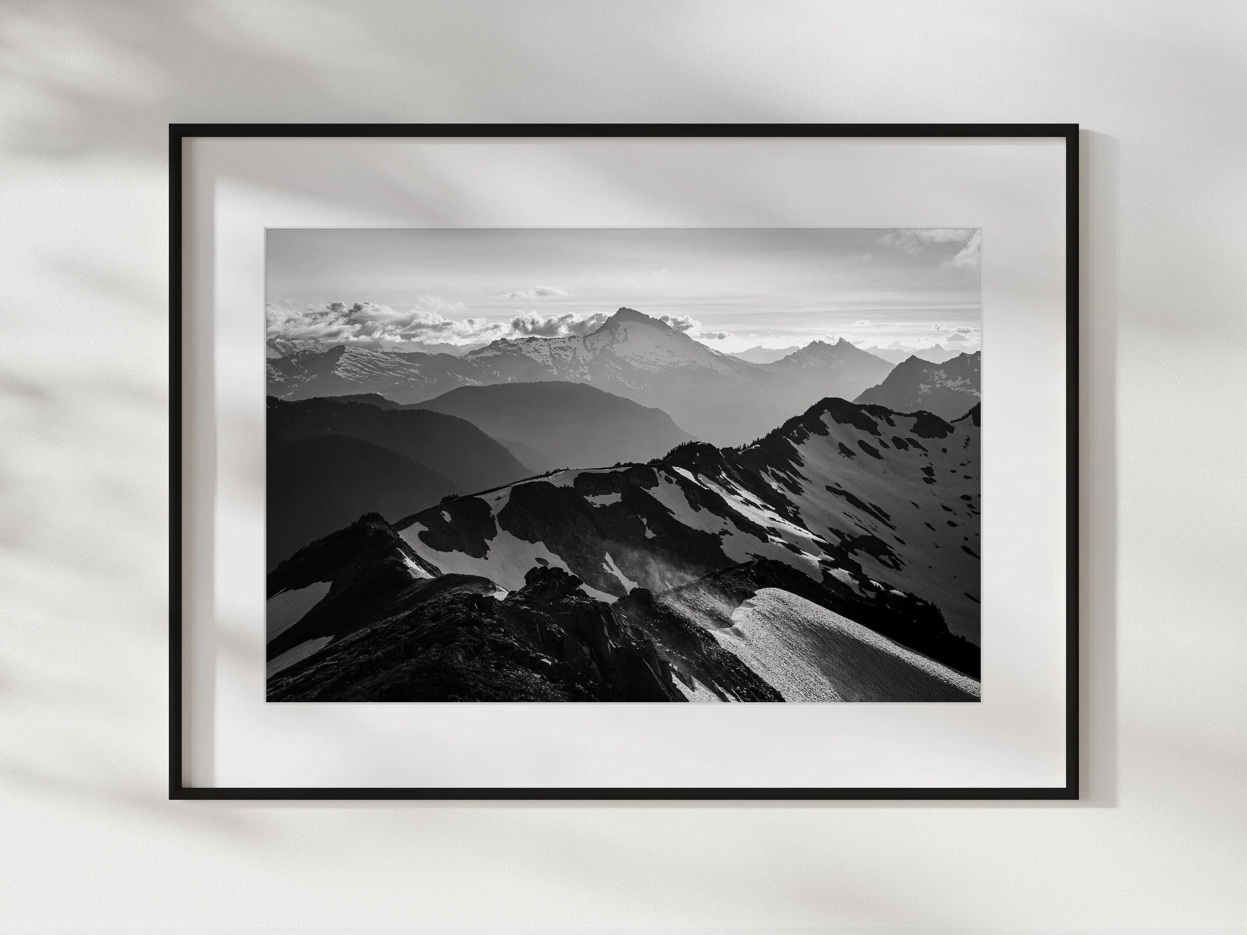 Black and white photograph of a mountain range on a wall with a white frame.