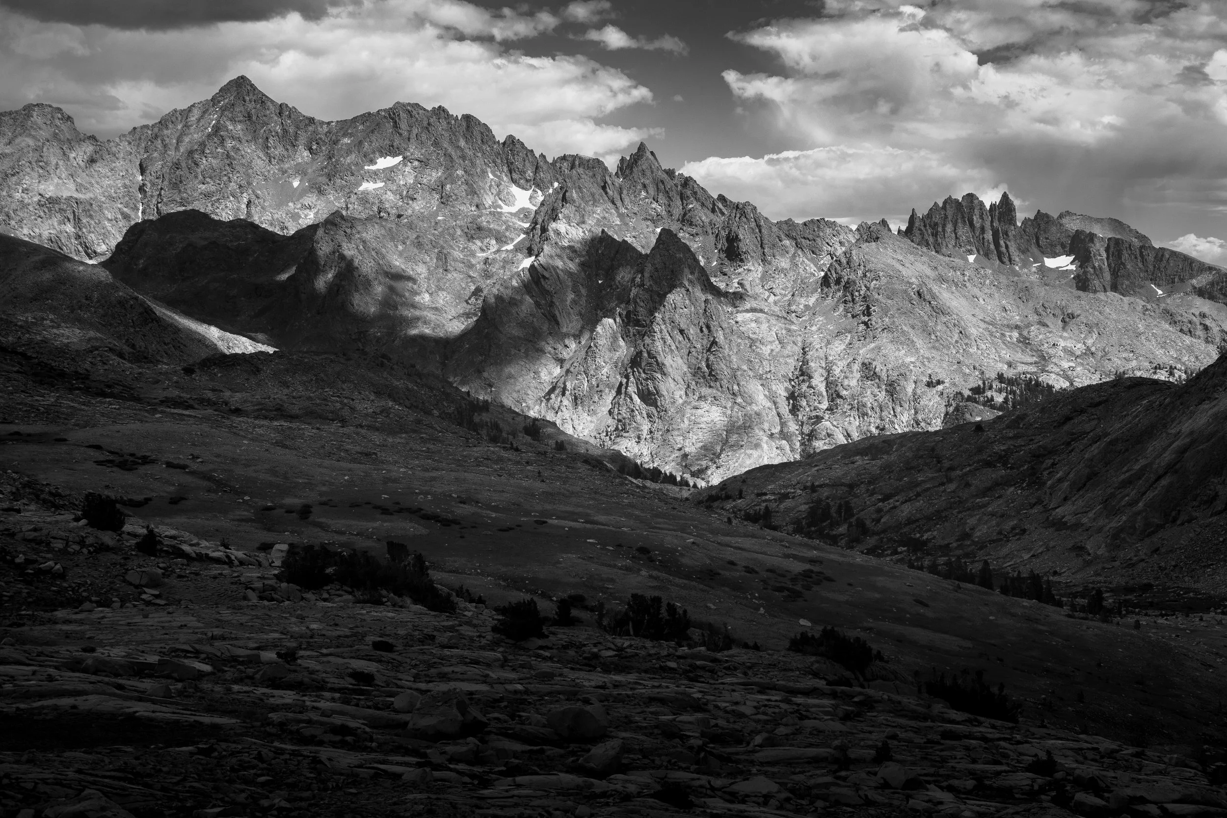 Black and white photograph of a mountain landscape with rugged peaks and a valley below