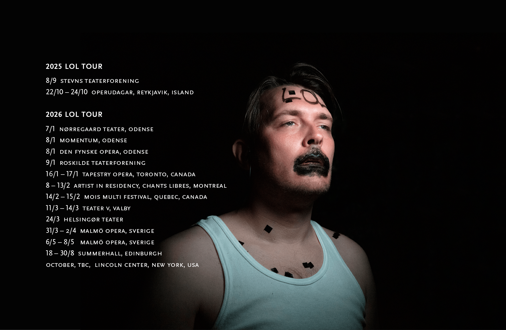 A man with black paint around his mouth and the words LOL written on his forehead. He emerges from a black background wearing a white vest. He is the solo performer in the opera Laughing Out Lonely.