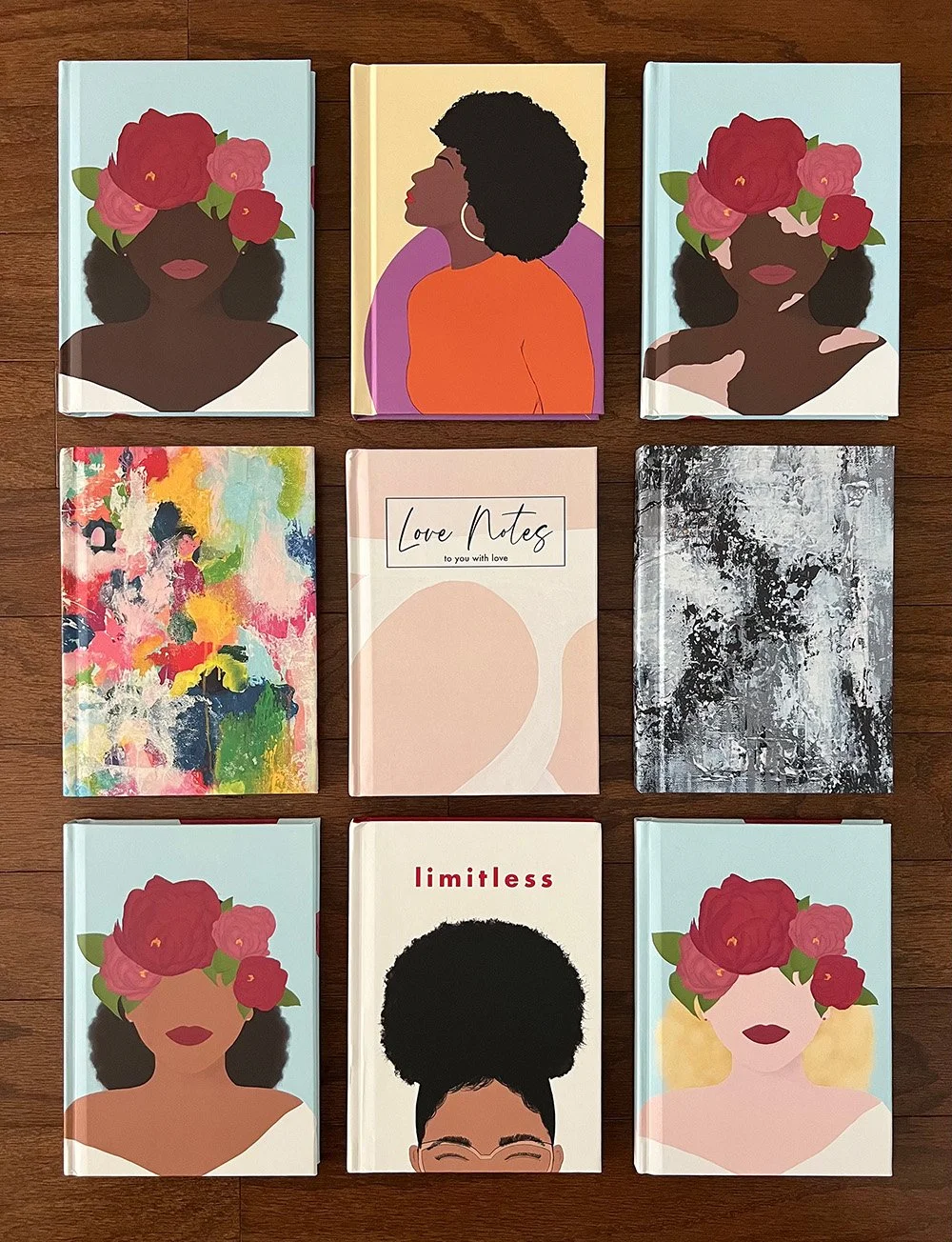 Nine notebooks arranged in a grid with decorative covers, featuring illustrations of women with natural hairstyles, floral accessories, and abstract designs.